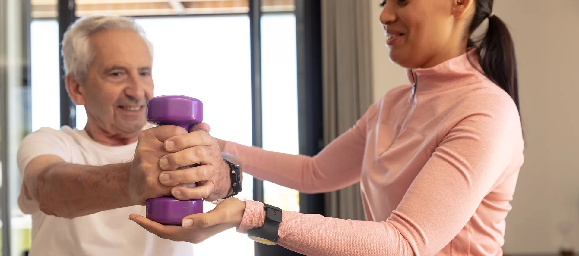 Senior exercising with caregiver support